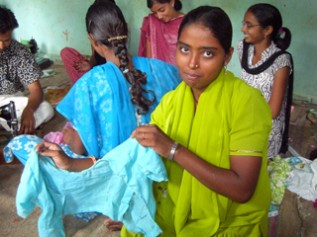 縫製の職業訓練を受けて自分で縫ったサリーを見せくれるインドの女の子