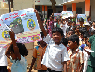 児童労働反対のポスターを掲げて行進するインドの子どもたち