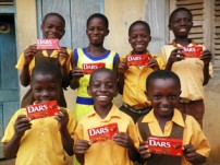 売上の一部で支援した地区の子どもたちにDARSを持ってもらって記念写真