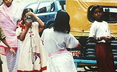 インスタントカメラを構え写真を撮るインドの子どもたち